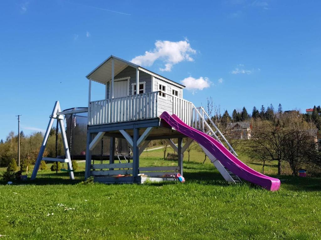 a playground with a house and a slide at Agroturystyka Koronkowe Zacisze in Koniaków