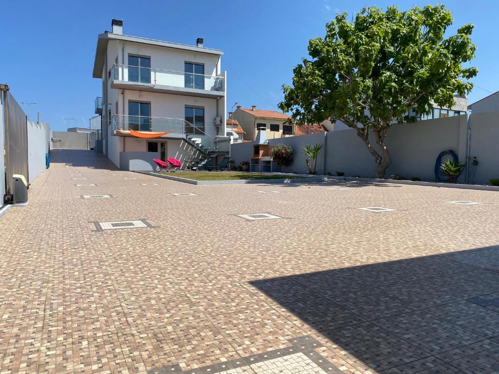 eine Backsteinstraße mit einem Baum und einem Gebäude in der Unterkunft Angeiras Beach House - Porto - Villa by the Sea in Lavra