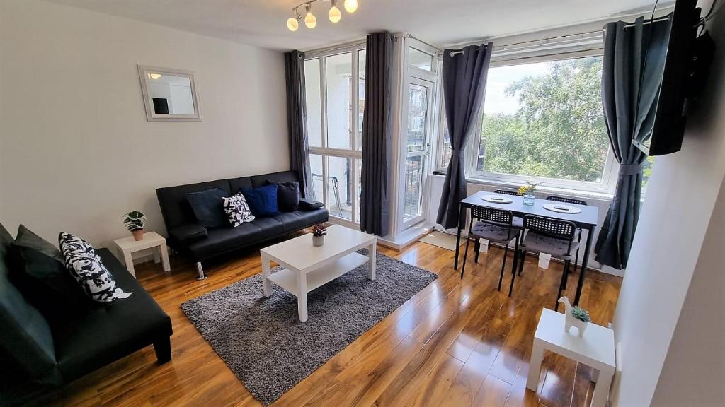 ein Wohnzimmer mit einem Sofa und einem Tisch in der Unterkunft Lovely 2 bed Flat in S/E London in Abbey Wood