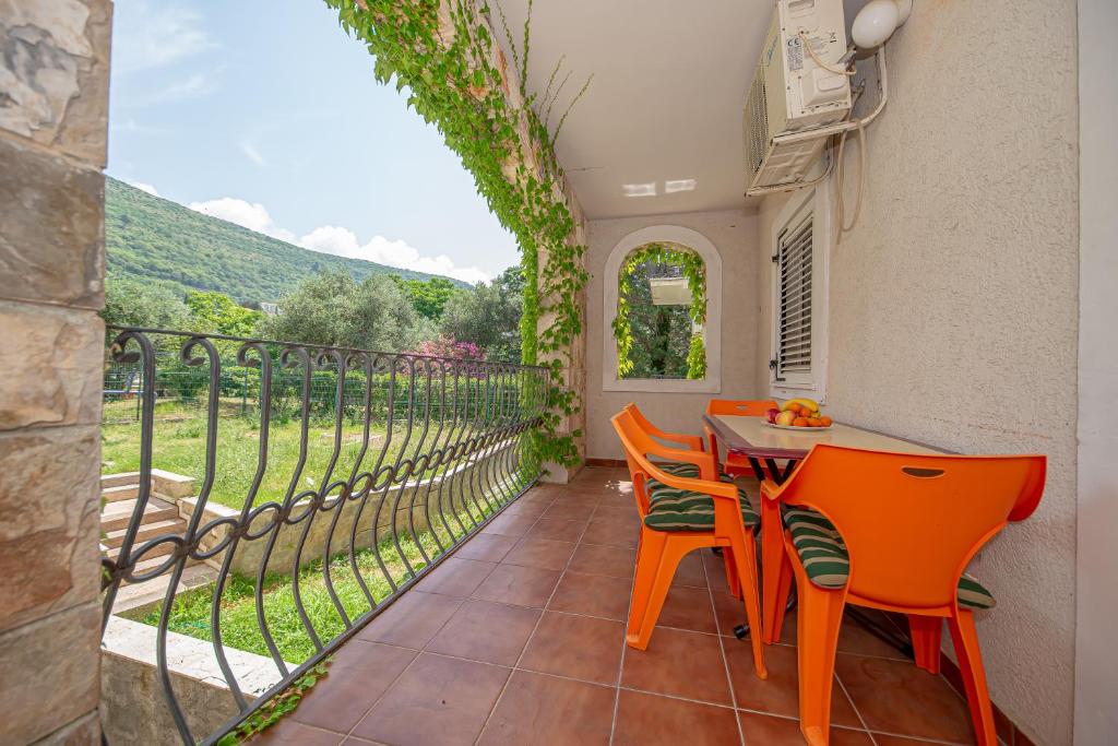 d'une terrasse avec des chaises orange et une table avec vue. dans l'établissement Beach apartments, à Petrovac na Moru