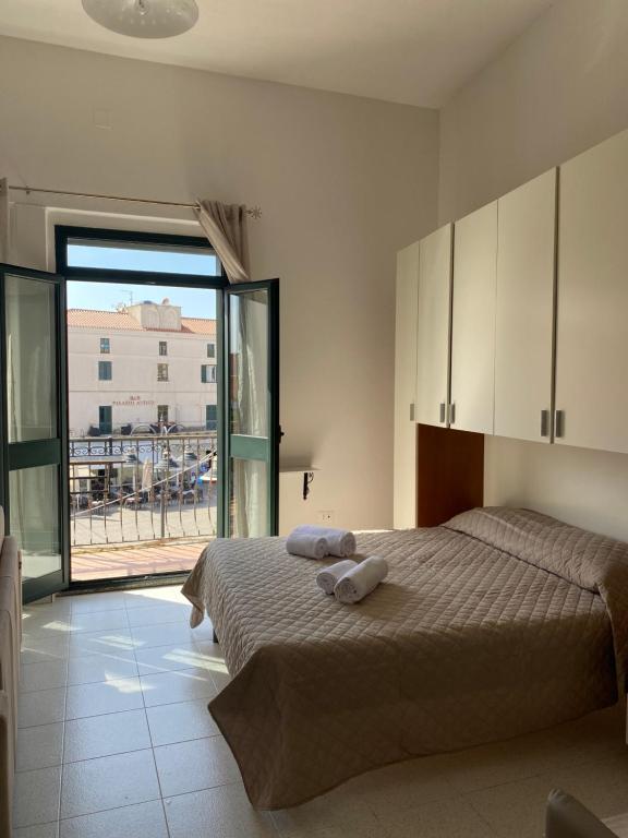 a bedroom with a bed and a large window at Monolocale Nonna Ita in Santa Teresa Gallura