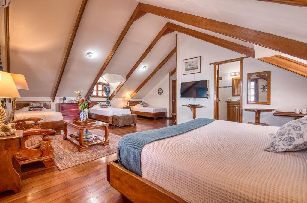 a bedroom with a large bed and a living room at Hotel Bocas del Toro in Bocas del Toro