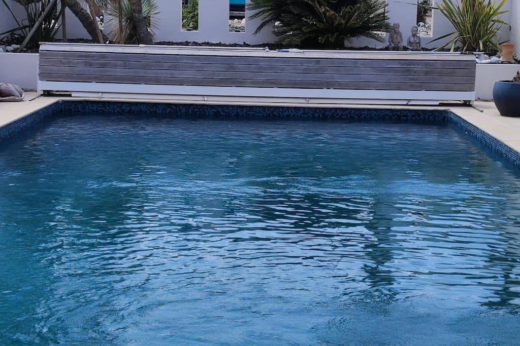 - une piscine avec un banc à côté dans l'établissement Joli havre de paix, à Prades-le-Lez