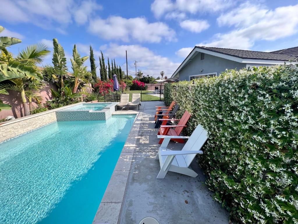 a swimming pool with lounge chairs next to a hedge at Cypress Villa Disneyland 8 Bedroom 4Bath Pool Game in Anaheim