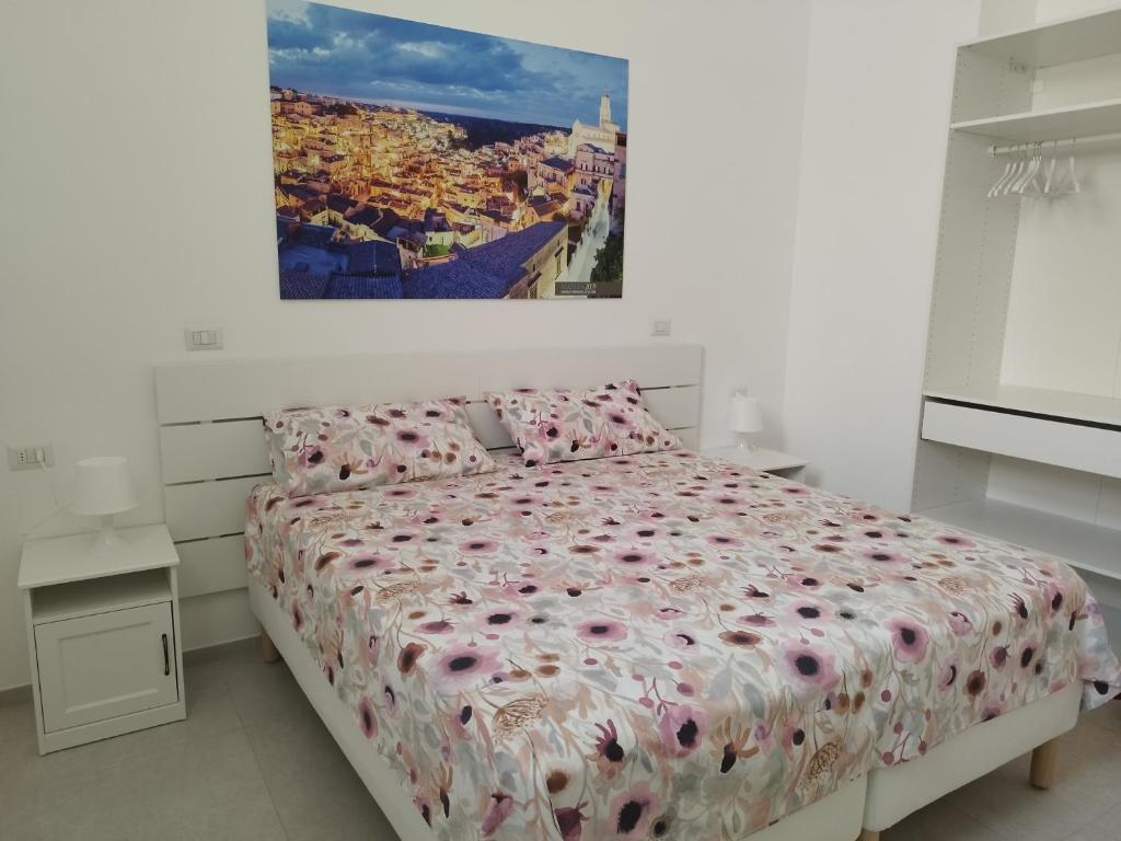 a bedroom with a bed with pink flowers on it at Le stanze del Maestro in Matera