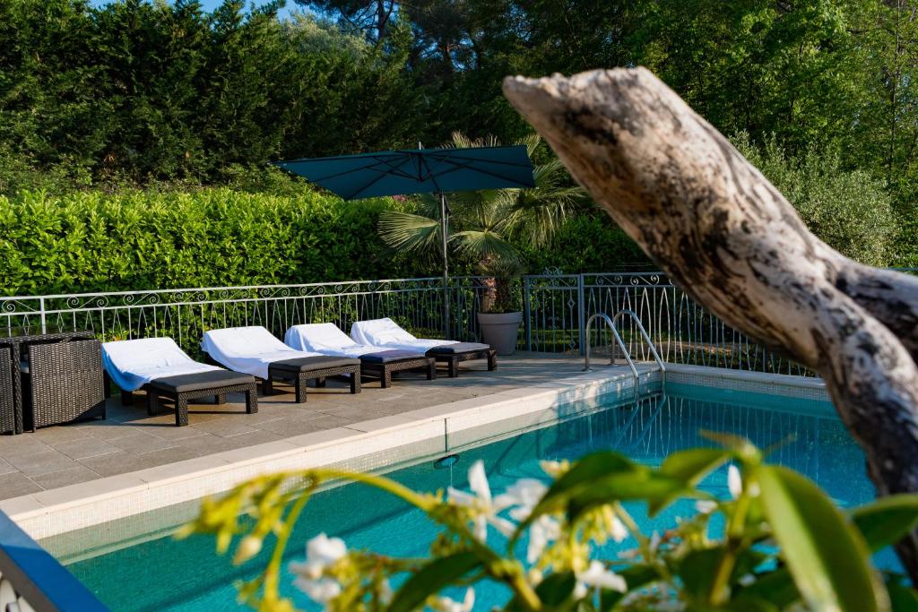 una piscina con tumbonas y sombrilla en Appartement Villa d'Aurore, en Le Rouret