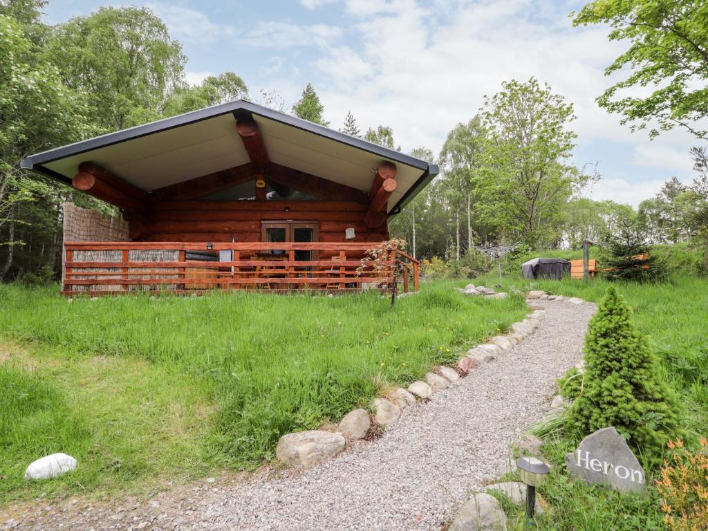 a log cabin with a gravel path in front of it at Heron Lodge in Inverness