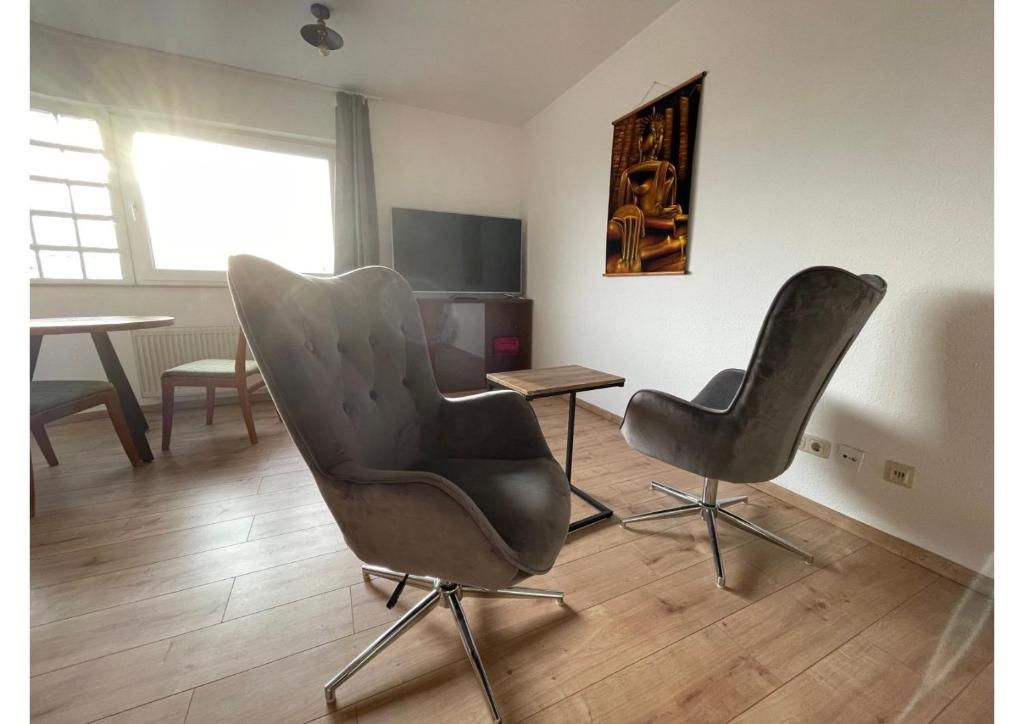 a room with two chairs and a table and a television at Sonnige Wohnung am Lindenauer Hafen in Leipzig