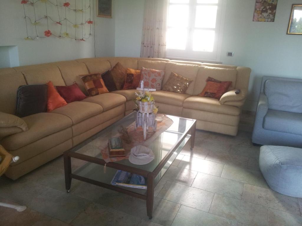 ein Wohnzimmer mit einem Sofa und einem Couchtisch in der Unterkunft Relais dei due Mari in Carmiano