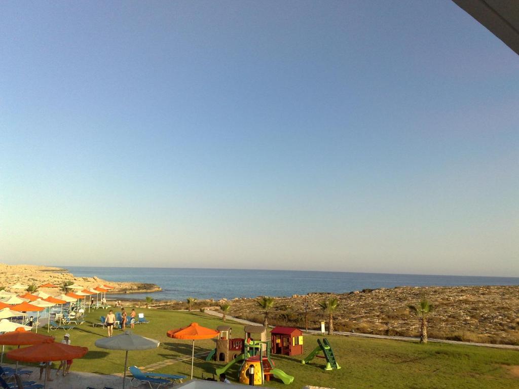 a group of people playing in a park near the ocean at Aktea Beach Village in Ayia Napa