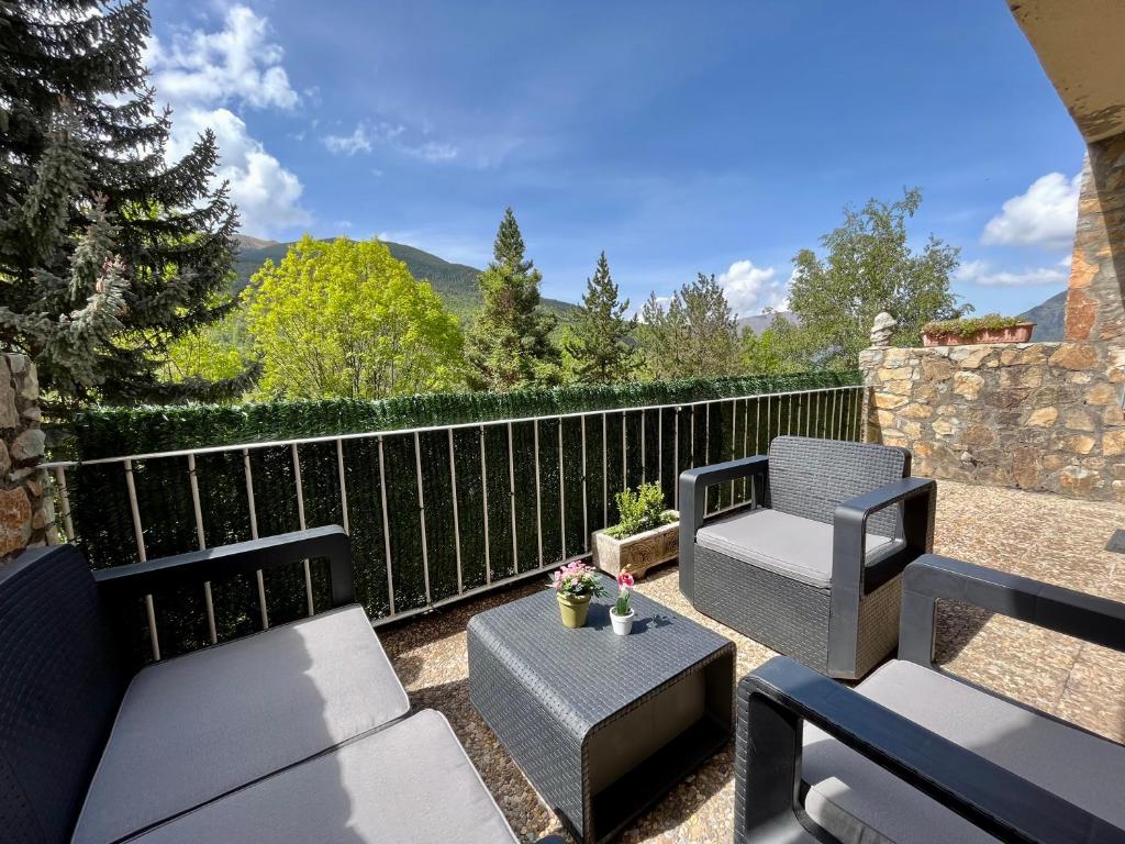 a patio with two chairs and a table and chairs at C20 - Alojamiento en Edif. Pirineos Cerler - Villmor in Cerler