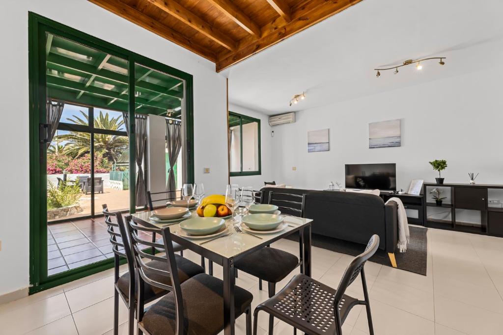 a dining room and living room with a table and chairs at Casa Mon in Costa Teguise