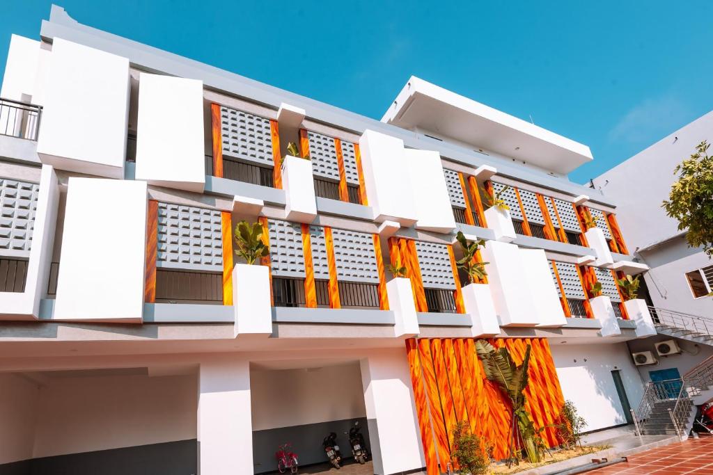 um edifício branco com persianas laranja em Ngọc Hoa - Nam Hội An Hotel em Thăng Bình