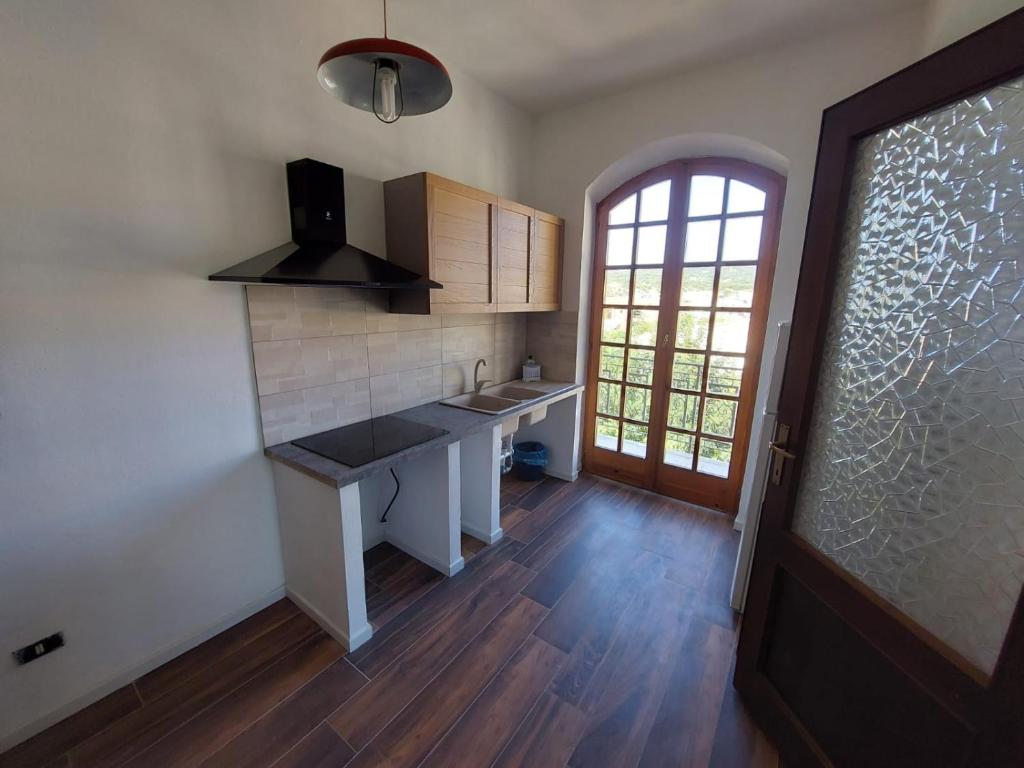 a kitchen with a counter and a sink and a window at Maison Umberto I a Villasimius centro in Villasimius
