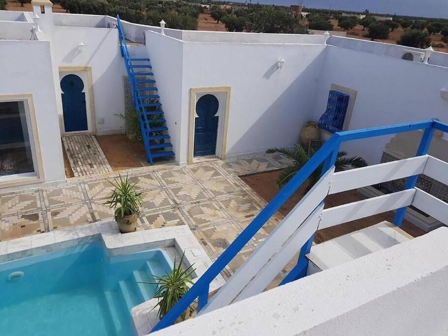 a villa with a swimming pool and a staircase to a house at Coeur des iles in Mellita