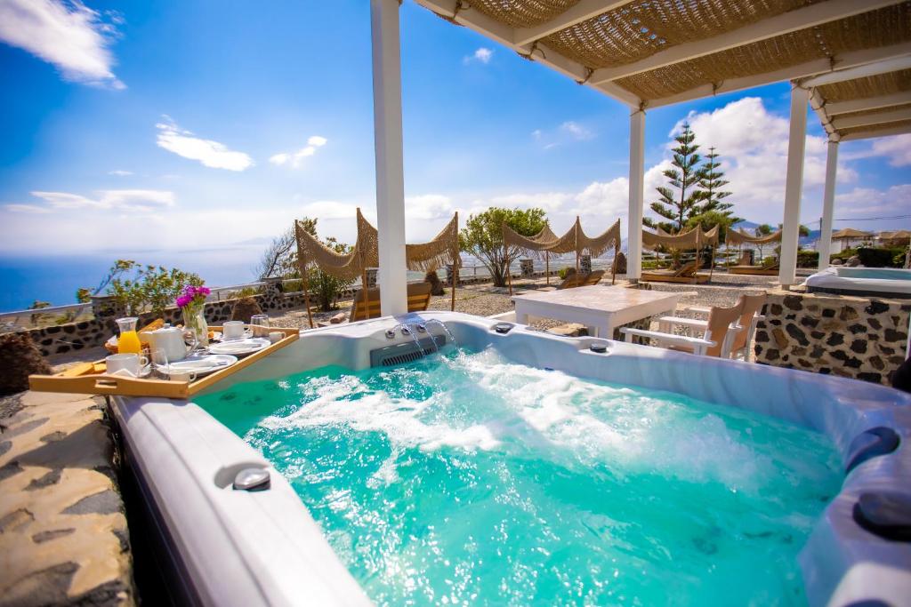 a hot tub on the patio of a resort at Phaos Santorini Suites in Imerovigli