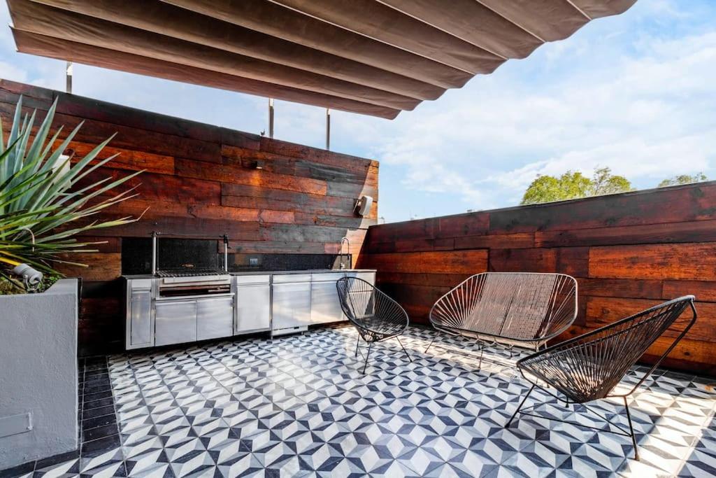 an outdoor patio with two chairs and a stove at Casa Mezcal. Arte, diseño y amenidades unicas. in Mexico City