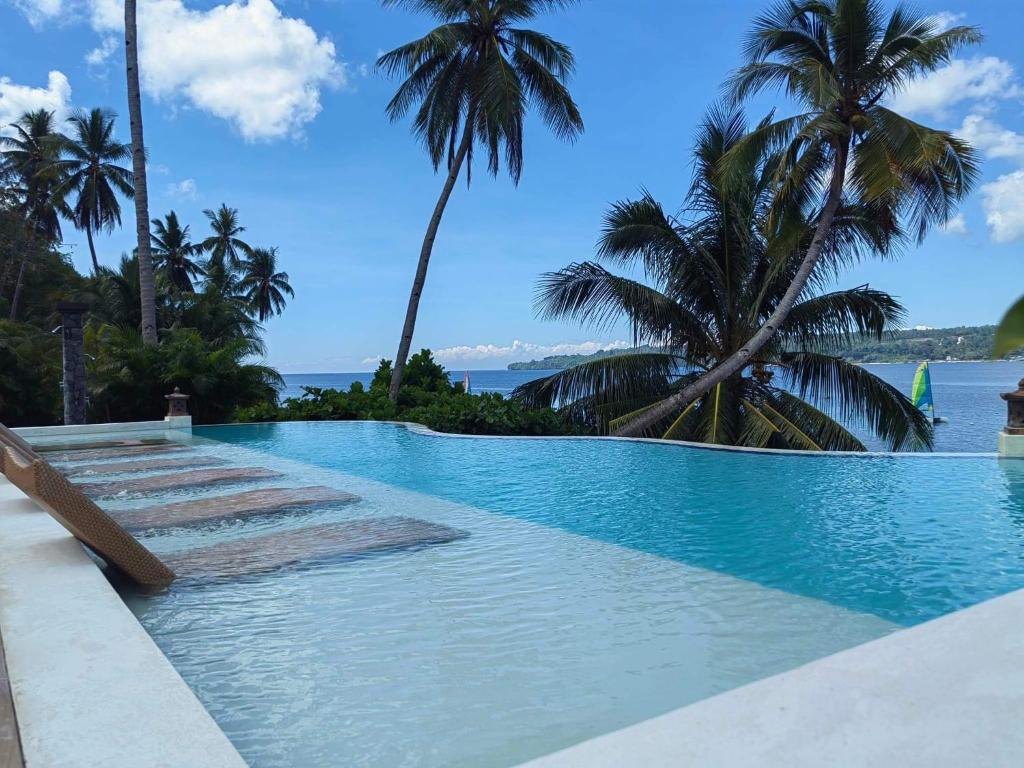 - une piscine avec vue sur l'océan et les palmiers dans l'établissement Samal Island Kembali Condo Resort, 