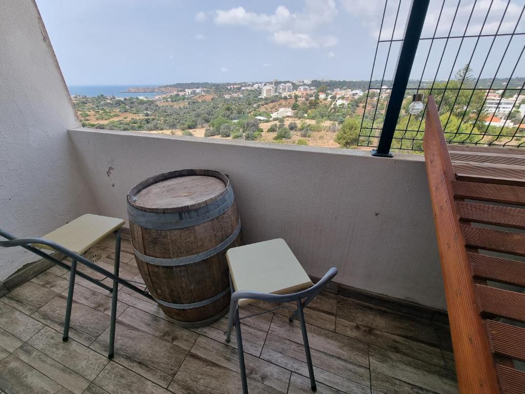 una habitación con 2 sillas y un barril en el balcón en Apartamento da Praia com jacuzzi, en Portimão