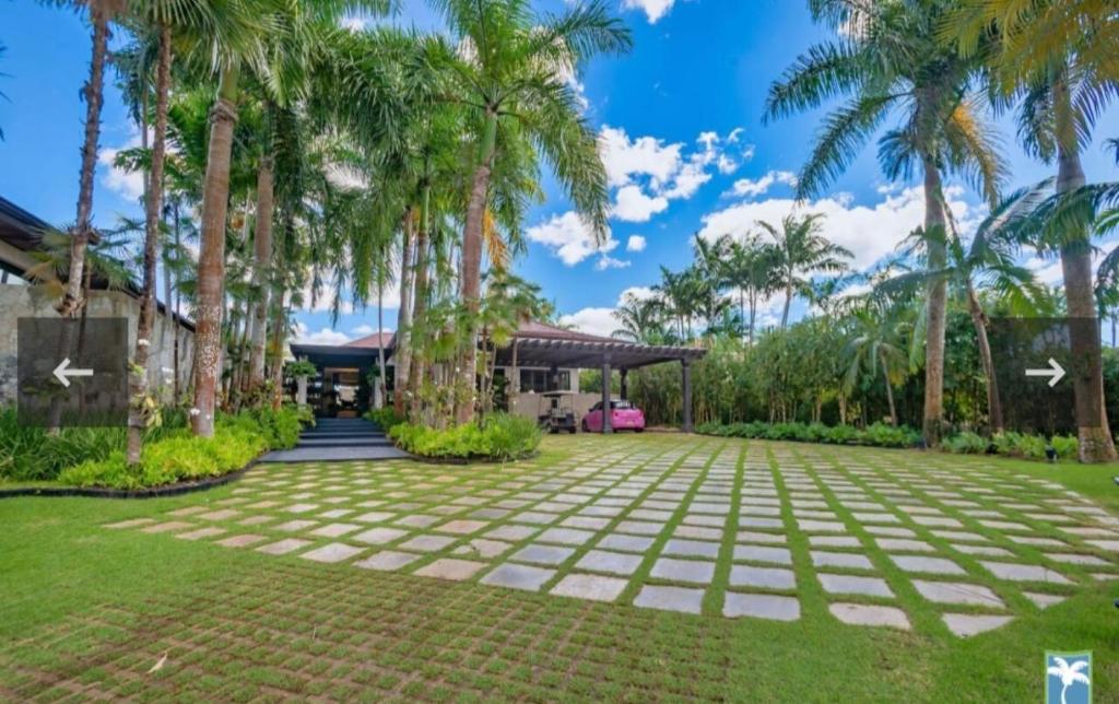 einen großen Innenhof mit Palmen vor einem Haus in der Unterkunft Holiday Villa 27 in La Romana