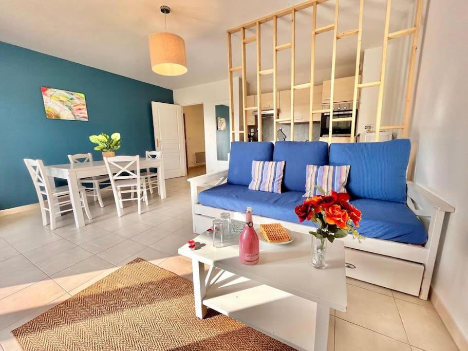 un salon avec un canapé bleu et une table dans l'établissement D34 La Ferme de Deauville 1 ch 1er étage SOZEN, à Saint-Arnoult