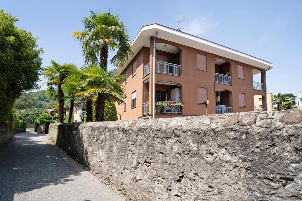um edifício com palmeiras em frente a uma parede em Casa del Sole em Lesa