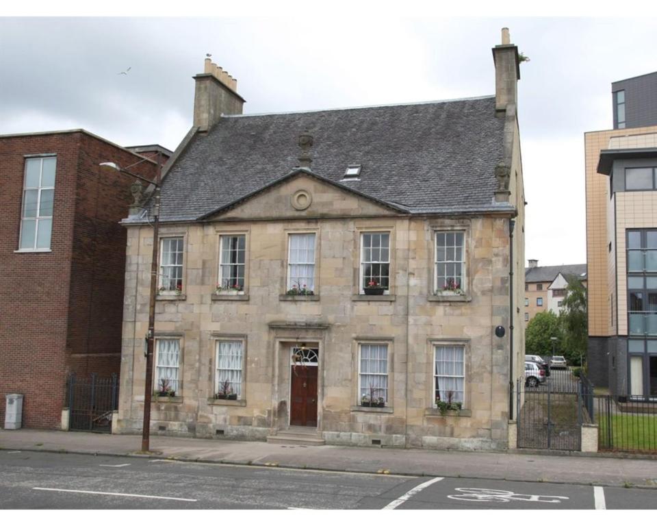 an old stone building on a city street at Glasgow City Apartments in Glasgow