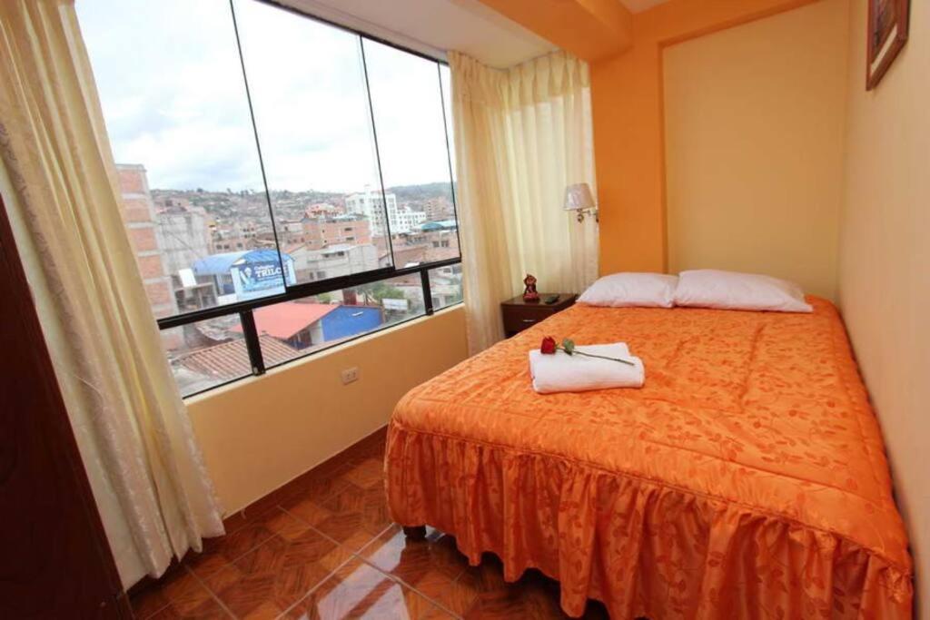um quarto com uma cama e uma grande janela em Appartments in Cusco em Cusco