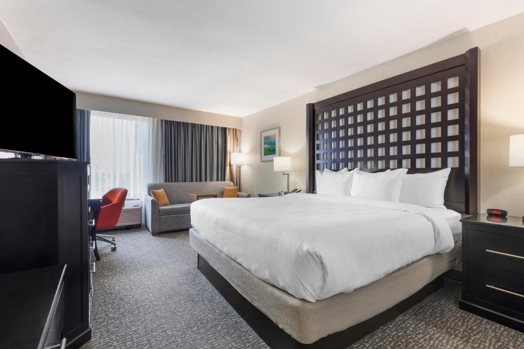 a hotel room with a large bed and a television at Comfort Inn Plano-Dallas in Plano