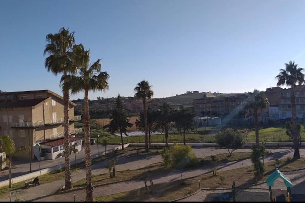 - une vue sur un parc avec des palmiers et des bâtiments dans l'établissement Appartamento via Roma, à Siculiana