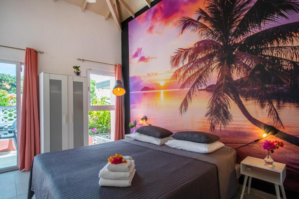 a bedroom with a palm tree mural on the wall at Happy Curoase in Willemstad