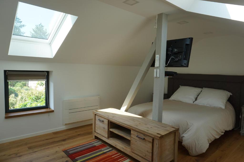 a bedroom with a bed and a tv and a window at KeschtaLoft - Gîte classé 4 étoiles in Châtenois