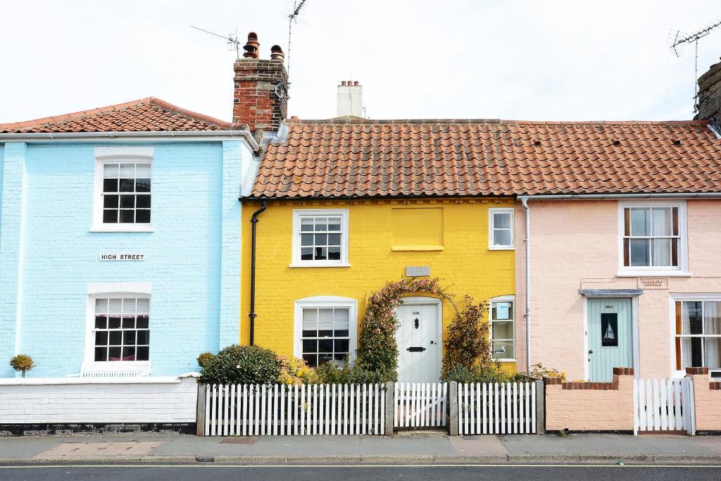 a row of colorful houses with a white fence at Aldeburgh Cottage in Aldeburgh
