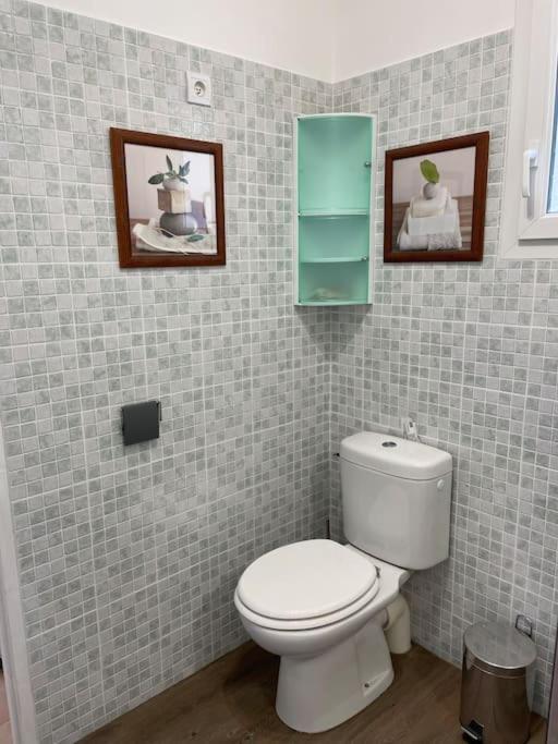 a bathroom with a toilet and two pictures on the wall at Le calme de la campagne proche de tout..... in Les Arcs sur Argens