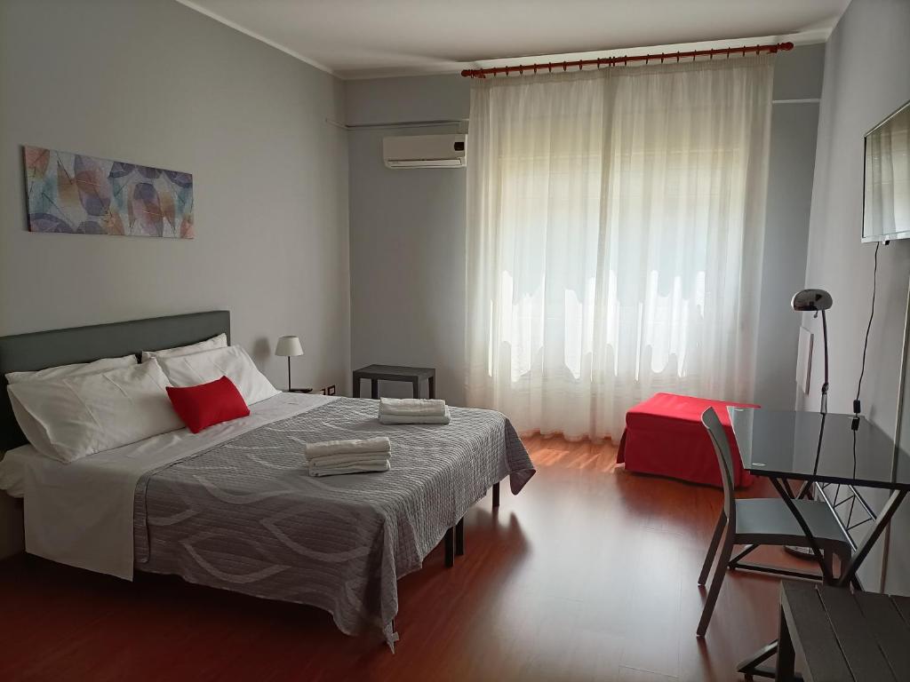 1 dormitorio con cama, mesa y escritorio en B&B Maltese en Palermo