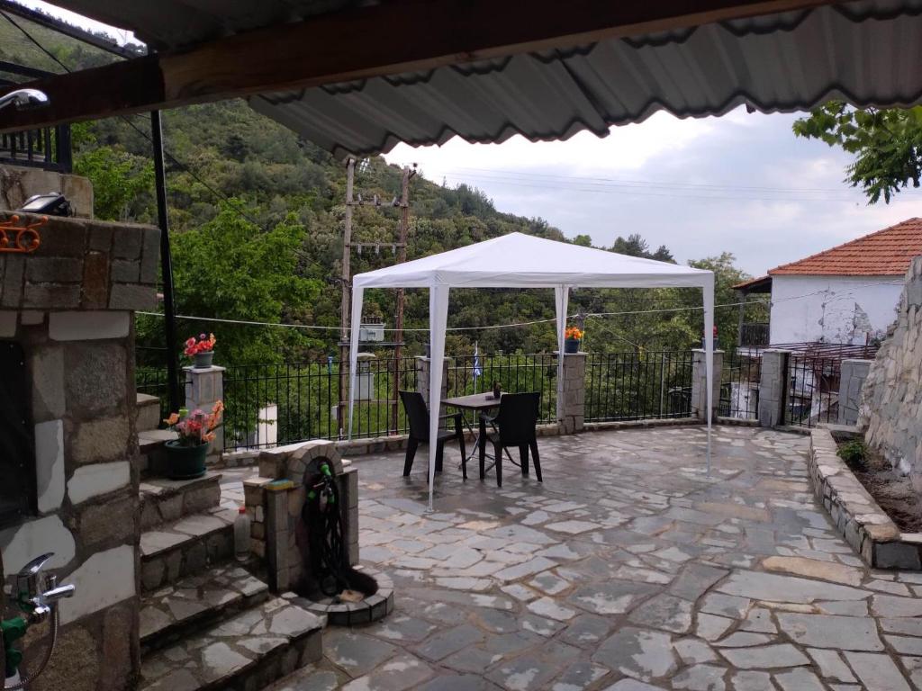 a patio with a table and a white canopy at Akis Apartments in Mariaí