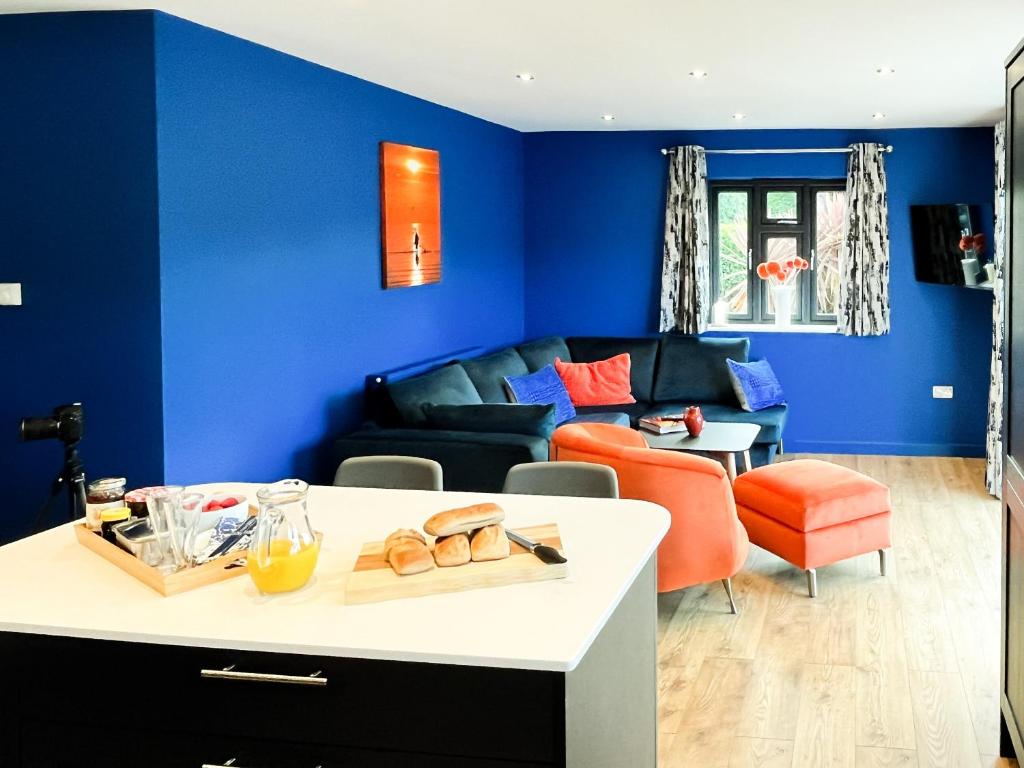 a living room with blue walls and a couch at Araglin in Worstead