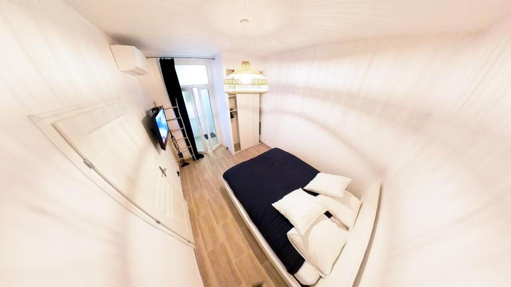 - une vue de tête sur une chambre avec un lit et un miroir dans l'établissement Superbe T2 calme & confortable - très bien situé!, à Ajaccio