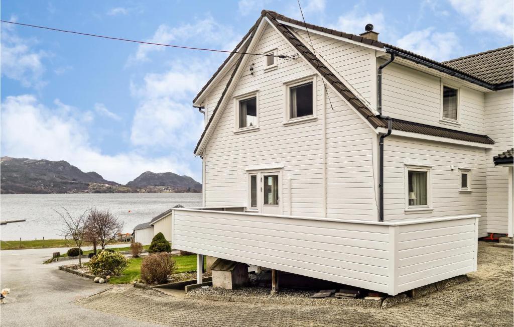 a white house on a pile of logs at Lovely Apartment In Sandnes With House Sea View in Forsand