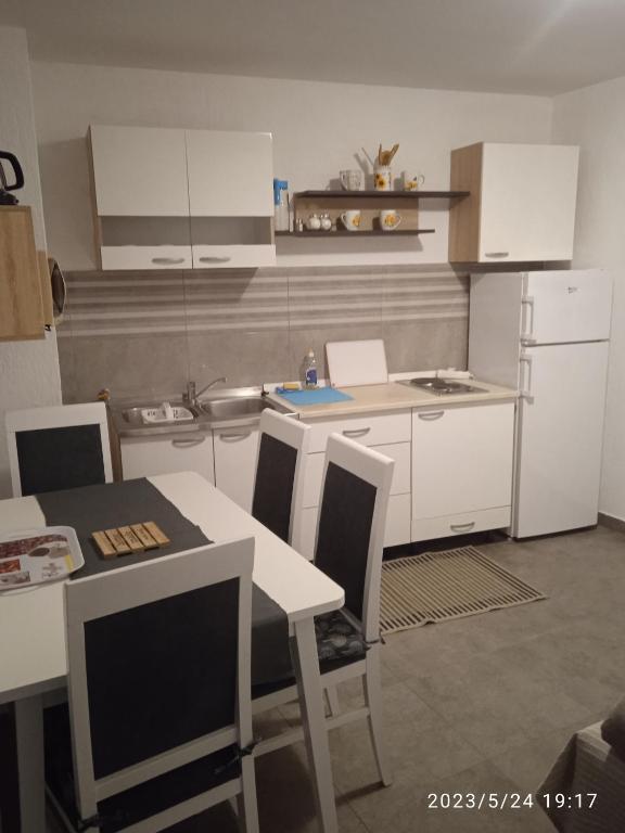 a kitchen with white cabinets and a table and chairs at Apartment Fortica in Senj