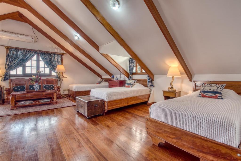 two beds in a attic room with wooden floors at Hotel Bocas del Toro in Bocas del Toro