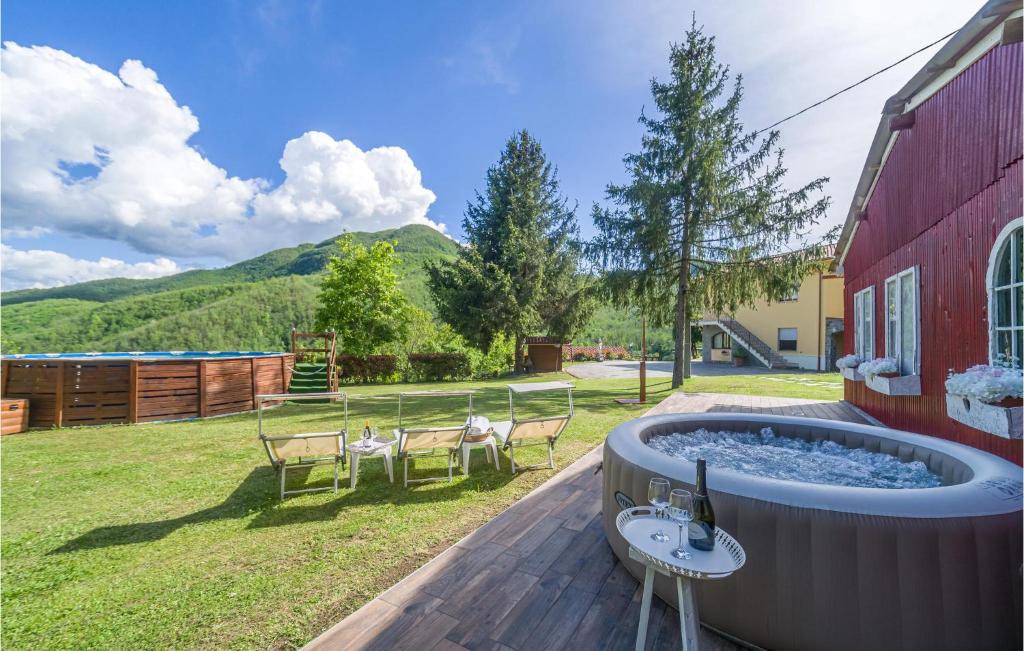 a hot tub on a deck next to a red building at Casa La Selva in Cavizzano