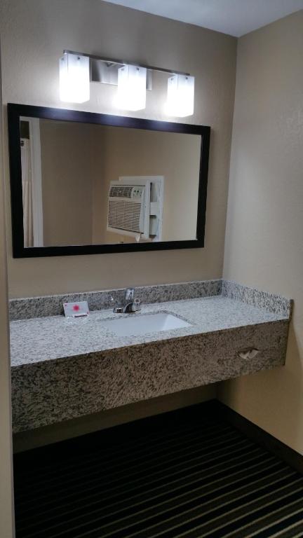 a bathroom with a sink and a mirror at Westbridge Inn & Suites in Clinton