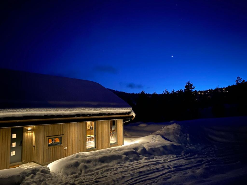 Stryn Mountain Lodge في سترين: مبنى مغطى بالثلج ليلا
