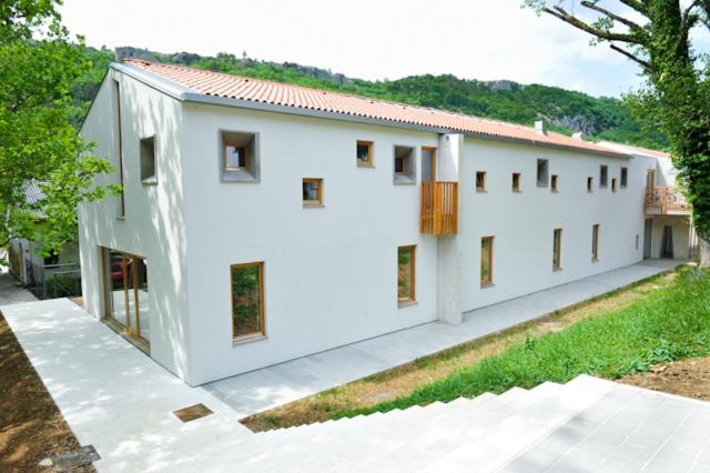 un edificio bianco con finestre sul lato di Youth Hostel Ajdovscina a Ajdovščina