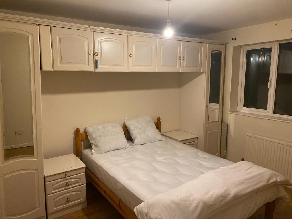 a small bedroom with a bed and white cabinets at La Mansion in Wednesbury