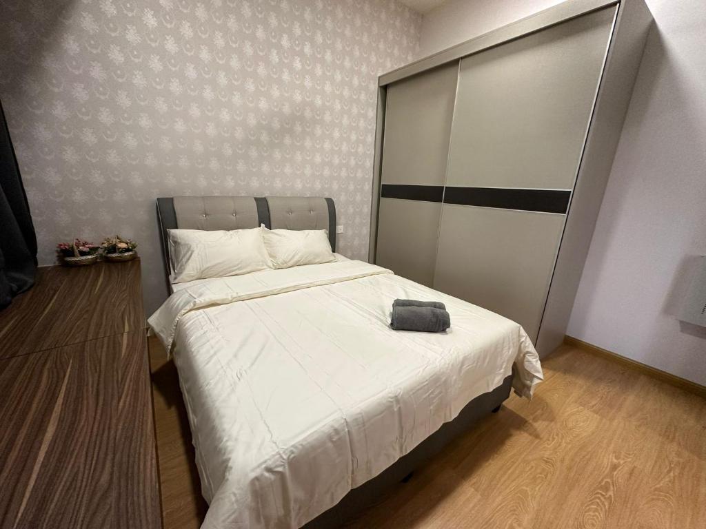 a small bedroom with a bed with a white bedspread at Flowers @ Country Garden Danga Bay in Johor Bahru