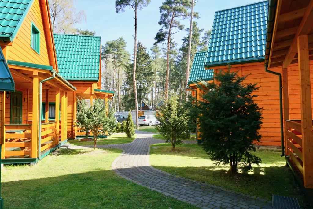 a walkway between two houses in a park at Zielone Domki in Pobierowo