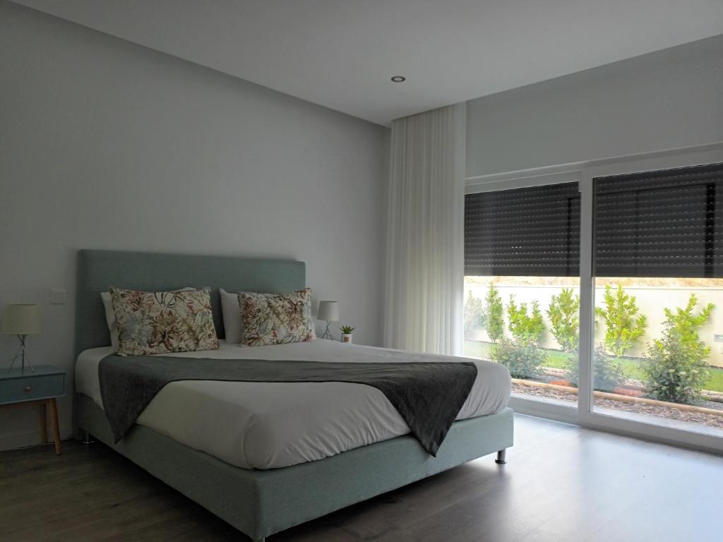 una camera con un letto e una grande finestra di Vila dArte Alojamento local situado no Centro do País a Vila de Rei
