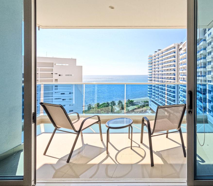 a balcony with chairs and a table and a view of the ocean at Reserva del Mar - Club de Playa, vista al Mar in Gaira